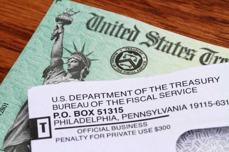 Social Security Could Run Out Sooner Than Expected A close-up of a U.S. Treasury check partially covered by an envelope from the U.S. Department of the Treasury, Bureau of the Fiscal Service, on a wooden surface.