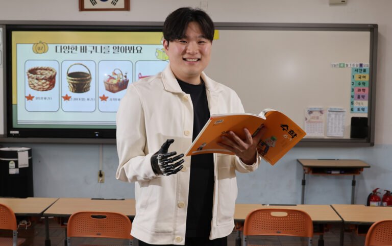 Kim Geun-hyo, a teacher at Baeksan Elementary School in Busan who lost his right arm during military service and now wears a prosthetic, poses for a photo in a classroom during an interview with the JoongAng Ilbo on April 16. [SONG BONG-GEUN]