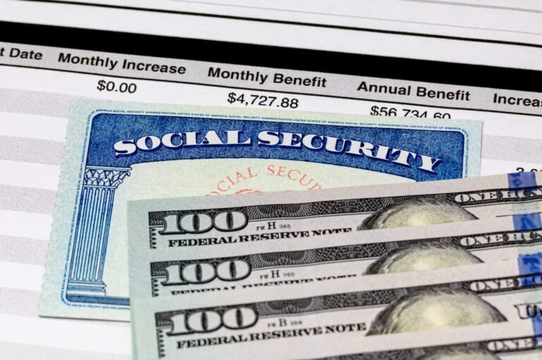 New Bill Could Let Working Retirees Keep Their Full Social Security Checks A close-up image showing a blue Social Security card with 'SOCIAL SECURITY' prominently displayed, overlaid on a document detailing 'Monthly Benefit $4,727.88' and 'Annual Benefit $56,734.60'. Below these, a fan of crisp US hundred-dollar bills is visible, partially obscuring the lower portions of the documents.