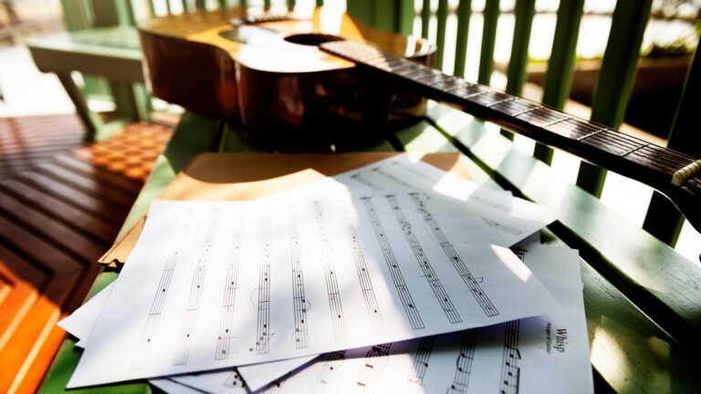A Music Therapy Study Examines the Needs and Challenges of Cancer Survivors blank music sheets scattered next to an acoustic guitar