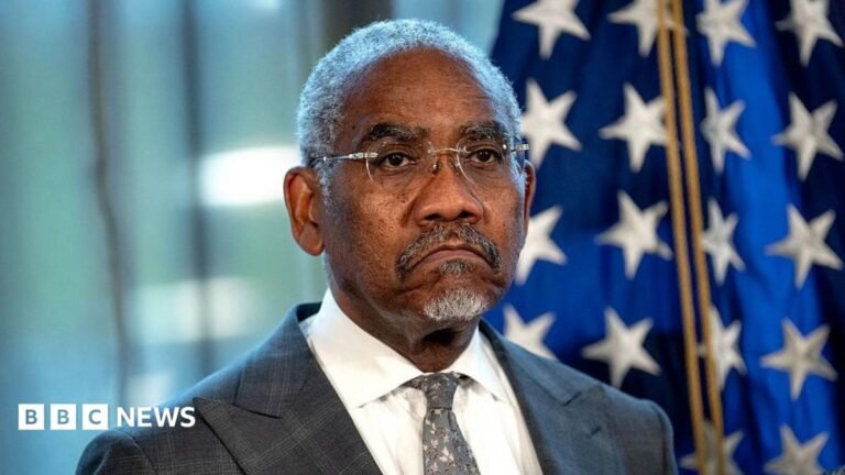 US congressman Gregory Meeks frowns in front of an American flag while attending a press conference