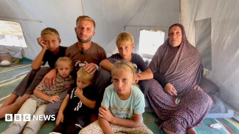 Gazans face near-daily Israeli strikes a year into ceasefire A man in his 30s sits with five children - two girls and three boys - and an older woman inside a tent in central Gaza