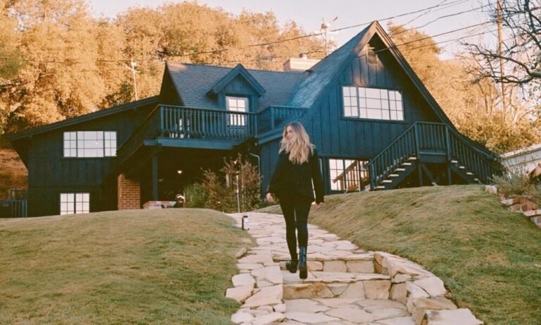 How Seasonal Trends Affect the Fall Real Estate Market Woman standing out the front of a house in the fall