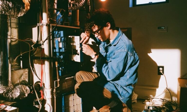 Simple Tips to Help Your Furnace Work Better This Winter Man working on a furnace in his basement